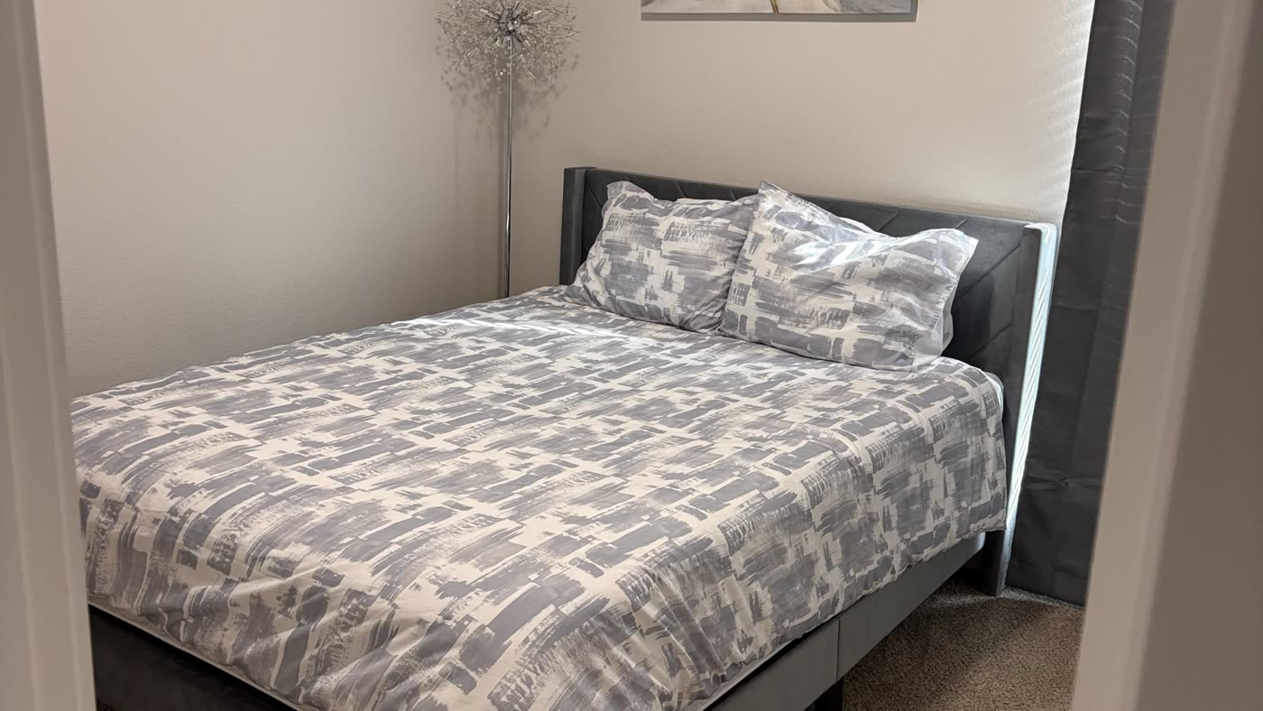 Guest bedroom with a made bed and clear surfaces