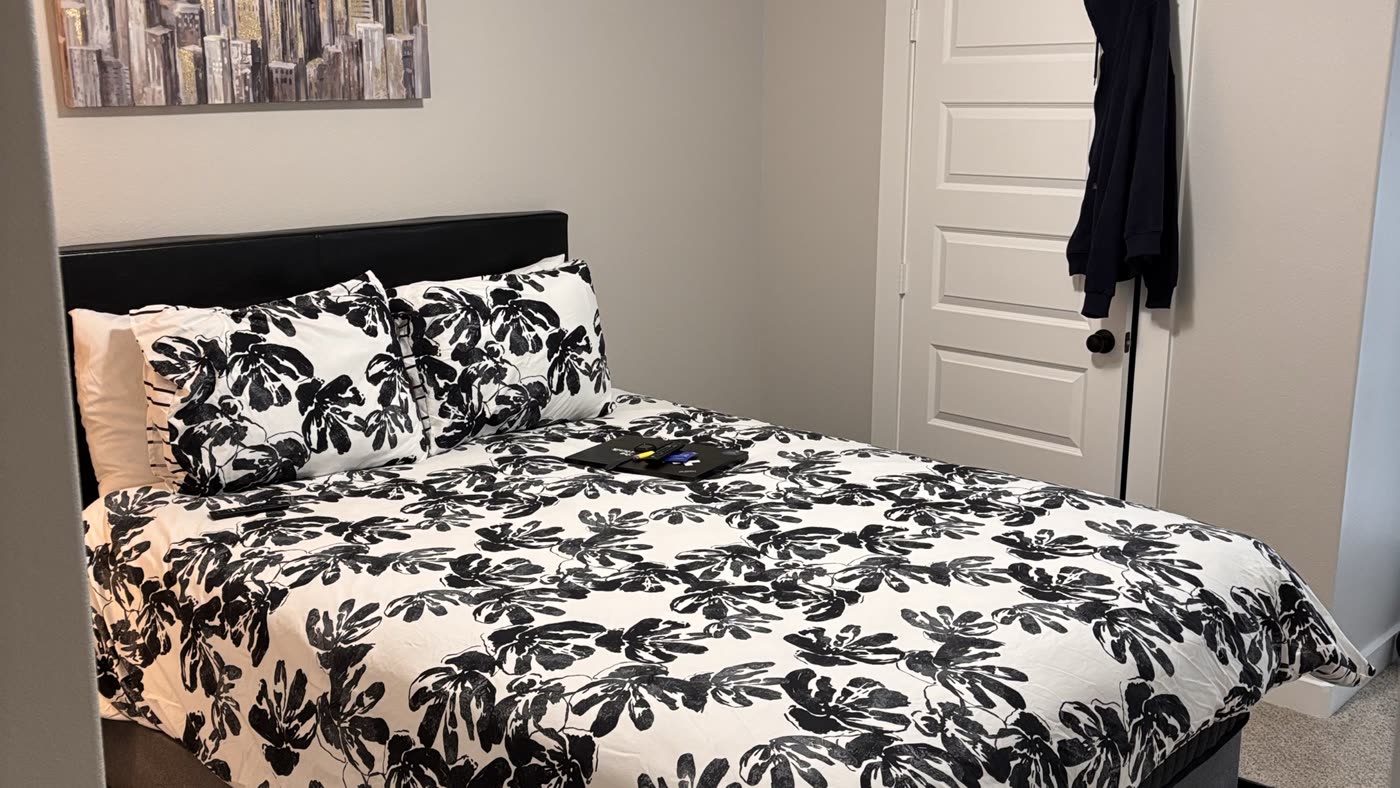 Primary bedroom with a freshly made bed and clean floors